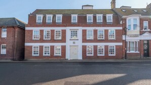 A two-story brick building with a central entrance, multiple windows, and a flat roof.