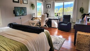 A bedroom with a bed, a desk, a chair, and a large window with a view. - Amazing views! Exclusive & peaceful Hawaii Kai. Walk to ocean & hikes, Pool, AC, (Honolulu)