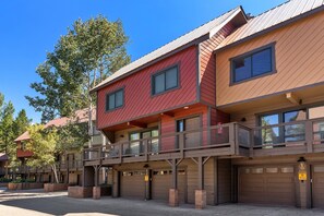 Residential building with a modern design, featuring a balcony and parking spaces.