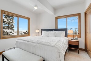 Relax in this serene bedroom with a large bed and stunning views of the snow-covered landscape.