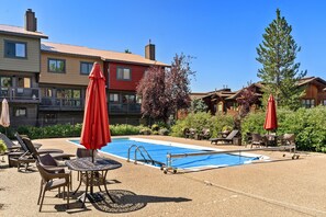Relax by the pool surrounded by lush greenery and comfortable lounge chairs.