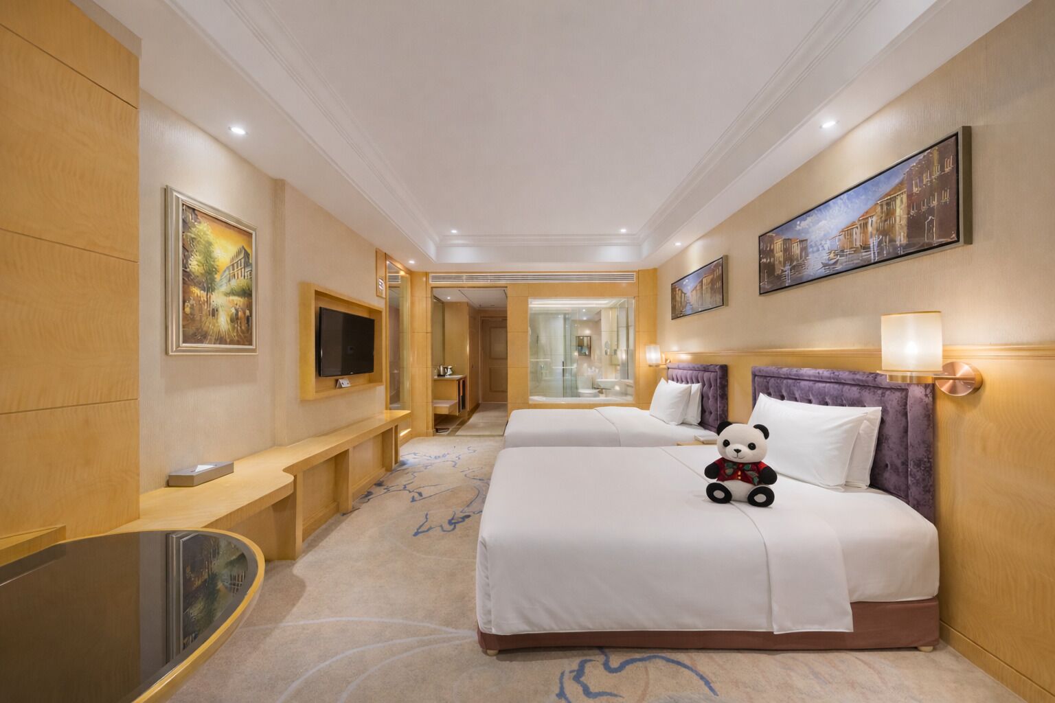 Een hotelkamer met twee bedden, een televisie, een bureau en een spiegel.