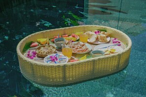 Ein Korbkorb mit Speisen und Getränken schwimmt auf einem Pool.