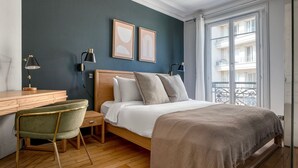 Une chambre à coucher avec un lit en bois, deux lampes de chevet, un bureau et une chaise.