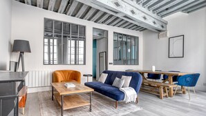 Una sala moderna con sofá, mesa de centro y mesa de comedor.