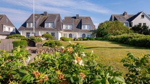 A row of houses with a well-maintained lawn and garden in the foreground.