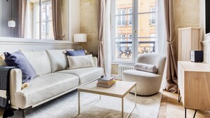 Un salon comprenant un canapé, un fauteuil, une table basse et un radiateur.