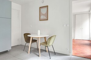 Simple, elegant space with a round table, two chairs, and a framed artwork.