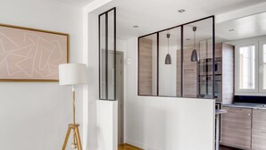 A modern kitchen with wooden cabinets, a built-in oven, and pendant lights. - Blueground | Michel-Ange Molitor, near tennis (Paris)