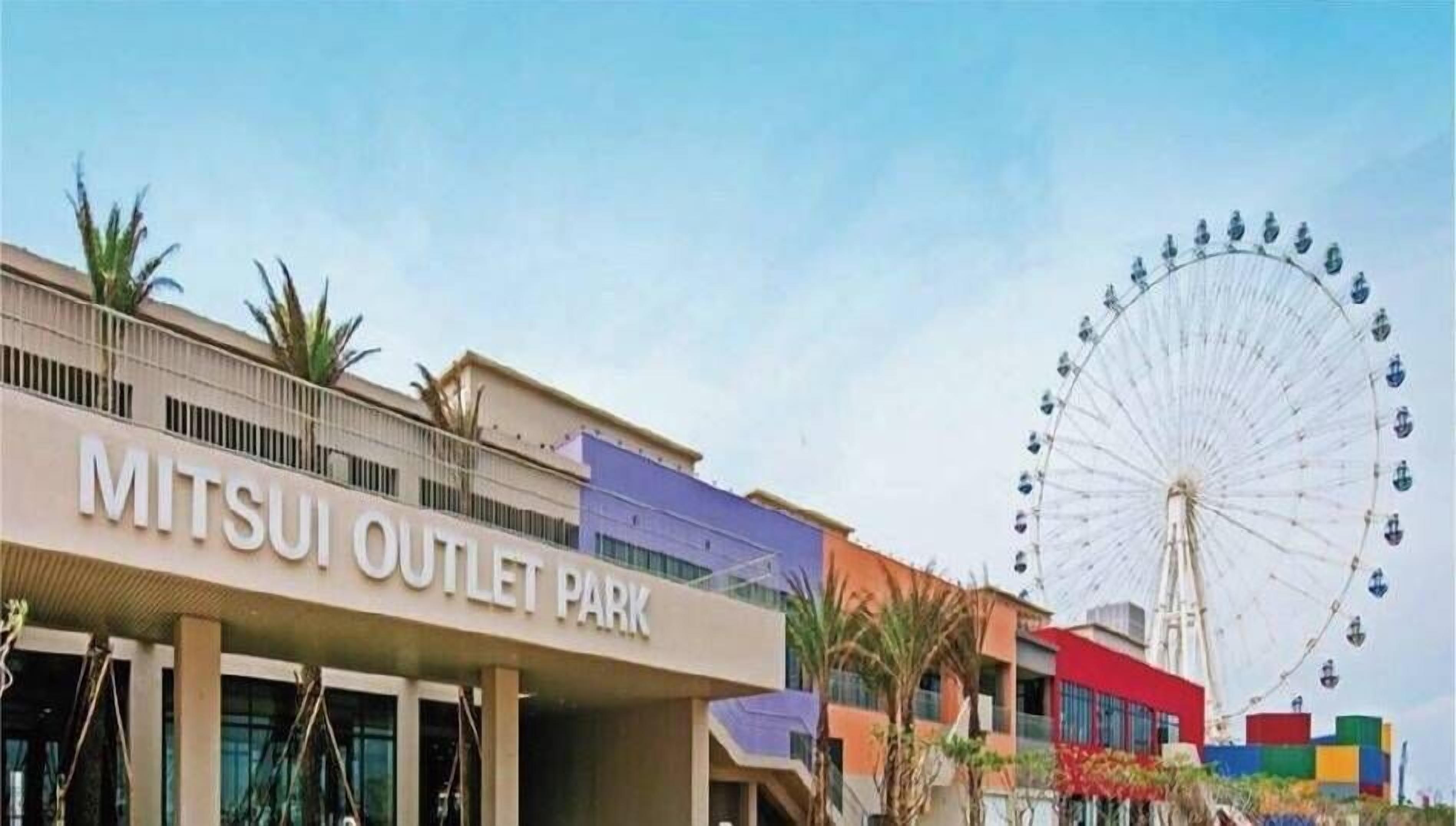 A building labeled "MITSUI OUTLET PARK" with a Ferris wheel in the background.