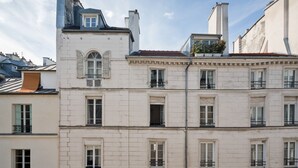 A multi-story building with a classic architectural style, featuring a prominent central window and multiple balconies.