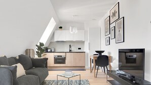 En moderne lejlighed med stue, spiseområde og køkken.