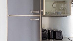 A kitchen with grey cabinets, a coffee maker, and a toaster. - Blueground | Le Marais, elev, nr rue de Bretagne (Paris)
