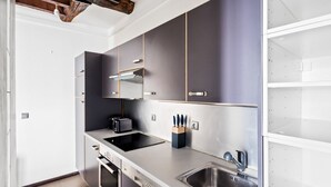 A modern kitchen with stainless steel appliances, a built-in oven, and a sink. - Blueground | Le Marais, elev, nr rue de Bretagne (Paris)