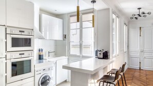 Een moderne keuken met inbouwapparatuur, een centraal eiland en barstoelen.