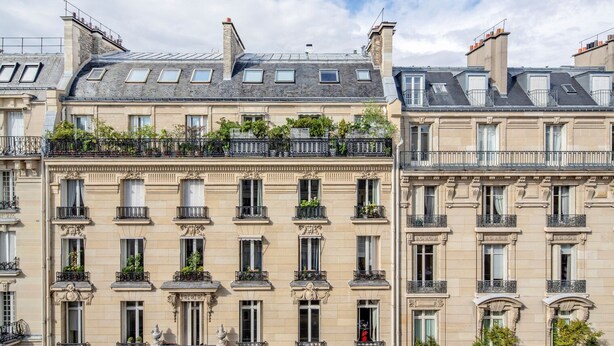 A row of classic Parisian buildings with uniform architectural style, featuring multiple balconies with wrought iron railings and small plants. - Blueground | Trocadéro, nr Eiffel Tower (Paris)