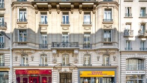 Un immeuble à plusieurs étages, de style architectural classique, caractérisé par des balcons richement décorés et de grandes fenêtres.