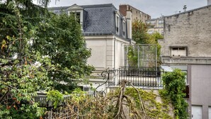A residential building with a grey roof, a white facade, and a balcony with a metal railing. - Blueground | Auteuil, balcony, nr Parc de Princes (Paris)