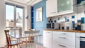 A modern kitchen with white cabinets, a microwave, and a kettle on the counter. - Blueground | Sentier, furnished, nr Montorgueil St (Paris)