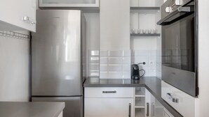 Una cocina moderna con electrodomésticos de acero inoxidable, una cafetera Bosch y armarios blancos.