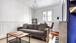 Un salon avec un canapé, une table basse et une cheminée.