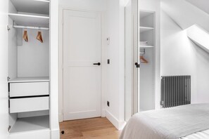 Ein Schlafzimmer mit einem Bett, einem weißen Kleiderschrank und einem Heizkörper.