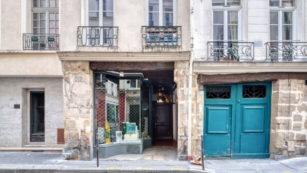 A two-story building with a ground-floor shop and a blue door. - Blueground | Le Marais, nr Les Halles (Paris)