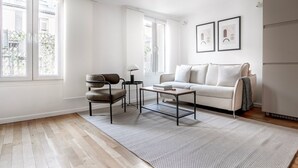 A modern living room with a sofa, armchair, coffee table, and a rug. - Blueground | Palais Royal, balcony, nr Louvre (Paris)