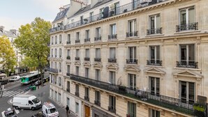 Un immeuble à plusieurs étages de style architectural classique, doté de balcons avec des garde-corps en fer forgé et d’une façade uniforme.