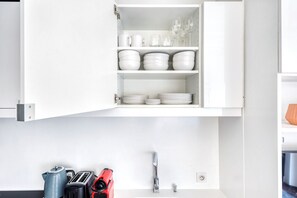 Kitchen features white cabinetry, a faucet, and modern appliances.