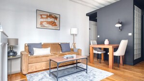 Ein modernes Wohnzimmer mit Sofa, Couchtisch und Esstisch.
