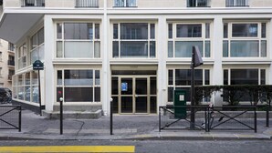 A multi-story building with a ground-level entrance, large windows, and a gated driveway. - Blueground | Porte de Champerret, elevator (Paris)