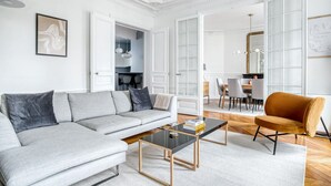 En moderne stue med en grå sofa, et sofabord og en sennepsgul lænestol.