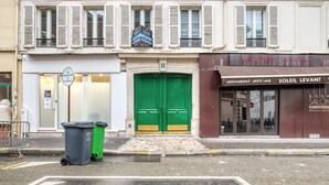 Une vue de rue avec une porte verte et une enseigne indiquant « RESTAURANT JAPONAIS » sur la droite.