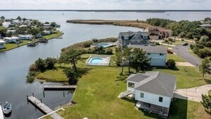 Een landgoed aan het meer met een groot huis, een zwembad en een steiger.