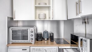 A compact kitchenette with a built-in toaster oven, a coffee maker, and a microwave. - Blueground | Villiers/Batignolles, fully furnished (Paris)