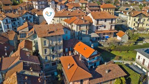 An aerial view of a residential area with closely packed houses, each featuring red-tiled roofs and balconies. - Luce - Lake View Balcony Apartment in Stresa Hill, Stresa, Italy (Stresa)