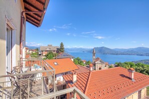 A residential area with terraced houses, a church, and a view of a lake and mountains.