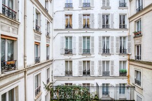 A multi-story building with white facades, shutters, and balconies. - Blueground | Ternes, elevator, nr Arc de Triomphe (Paris)