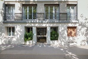 Stylish two-story building with a flat roof and balcony, featuring a clean, minimalist design.