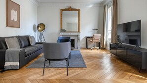 Un soggiorno moderno con divano, poltrona, televisione e camino.