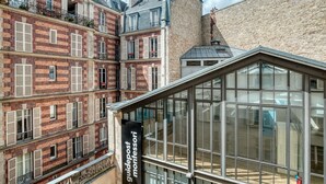 Un edificio a più piani con veranda in vetro e facciate in mattoni.
