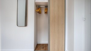Ein modernes Badezimmer mit einem Holzbettchen, einem Spiegel und einem Handtuchhalter mit gefalteten Handtüchern.