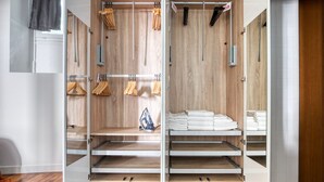A walk-in closet with wooden paneling, multiple shelves, and hanging storage for clothes and accessories.
