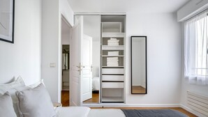 Ein Schlafzimmer mit einem Bett, einem Kleiderschrank und einem Spiegel.