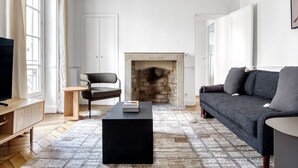 Un salon avec une cheminée, un canapé, un fauteuil et une table basse.