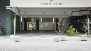 L’entrée d’un immeuble, avec une enseigne indiquant « 39 TOUR DE SEINE » et une porte en verre.