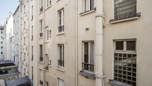 A row of beige buildings with multiple windows and balconies.