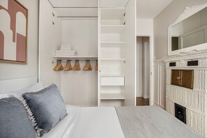 A bedroom with a bed, a wardrobe, and a fireplace. - Blueground | Trocadero, nr metro & parks (Paris)