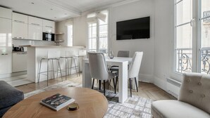 A modern kitchen with white cabinets and a dining area with a table and chairs.
